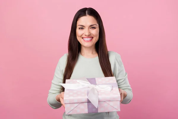 Foto de encantadora feliz joven agradable dar regalo sonrisa aislada sobre fondo de color rosa pastel —  Fotos de Stock
