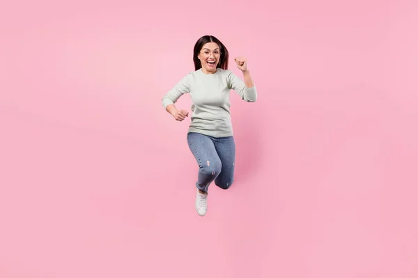 흥분 한 행복 한 아가씨의 전체 크기 사진당신은 파스텔 핑크 색 배경에 고립된 선수 위로 뛰어 오른다 — 스톡 사진
