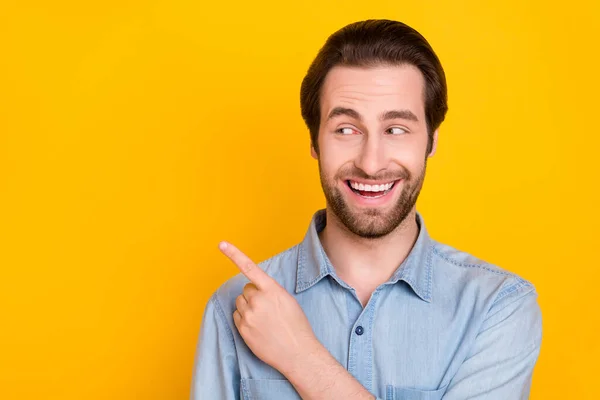 Retrato fotográfico del joven sonriendo señalando espacio en blanco aconsejando positivo aislado sobre fondo de color amarillo vivo — Foto de Stock