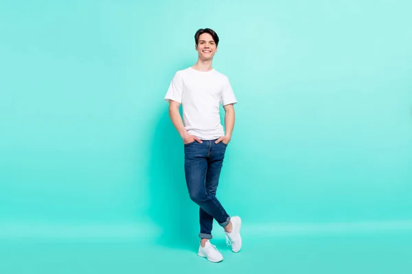 Piena lunghezza corpo formato foto allegro ragazzo in bianco t-shirt blu jeans sorridente felice isolato vivido colore turchese sfondo — Foto Stock