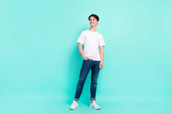 Ganzkörper-Foto von schönen brünetten Frisur Teenager Kerl sehen leer Raum tragen T-Shirt Jeans isoliert auf teal Farbhintergrund — Stockfoto