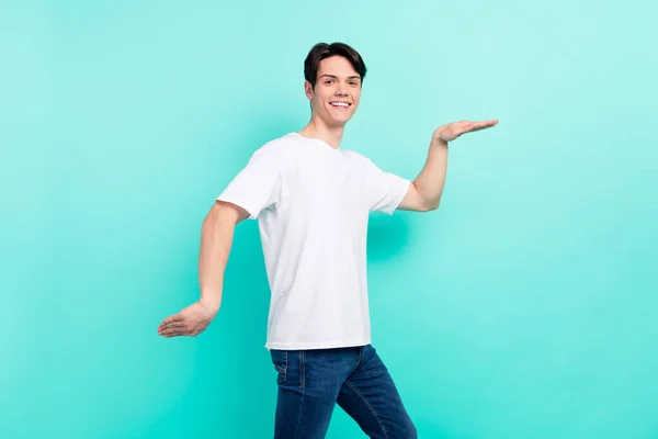 Profil foto av rolig brunett frisyr tonåring kille dans bära t-shirt jeans isolerad på livlig teal färg bakgrund — Stockfoto