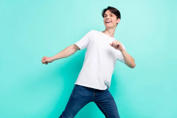 Bild av cool brunett frisyr tonåring kille dans ser tomt utrymme bära vit t-shirt isolerad på livlig teal färg bakgrund — Stockfoto