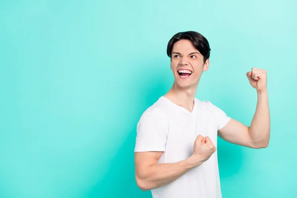 Foto av galen brunett frisyr tonåring kille händer nävar skrika titta tomt utrymme bära vit t-shirt isolerad på levande teal färg bakgrund — Stockfoto