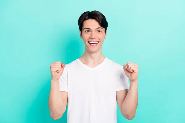 Foto porträtt ung kille bär vit t-shirt gest som vinnare isolerad ljus teal färg bakgrund — Stockfoto