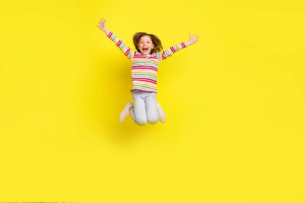 Pleine photo du corps de cheveux courts impressionnés petite fille saut porter chemise pantalon baskets isolé sur fond de couleur jaune — Photo