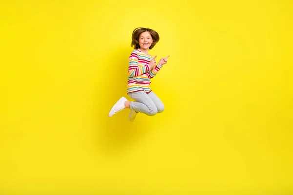 Full kropp foto av charmiga glada unga lilla flicka hoppa upp pekfingret tomt utrymme isolerad på gul färg bakgrund — Stockfoto