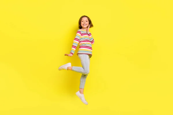 Teljes méretű fotó vidám rövid frizura kis lány ugrás kopás ing nadrág cipő elszigetelt sárga színű háttér — Stock Fotó