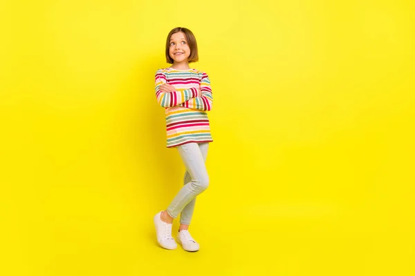 Teljes hosszúságú fotó elég rövid frizura kis lány keresztbe karok néz üres tér kopás ing nadrág elszigetelt sárga színű háttér — Stock Fotó