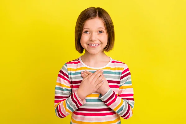 Foto de lindo penteado curto menina pequena mãos coração desgaste camisa colorida isolado no fundo de cor amarelo vívido — Fotografia de Stock