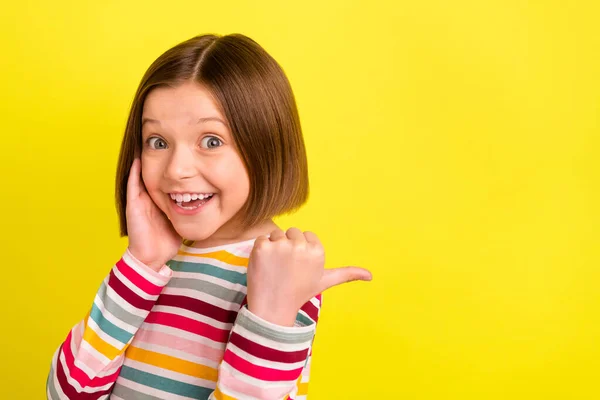 Φωτογραφία πορτρέτο κοριτσάκι αγγίζοντας μάγουλο δείχνοντας copyspace αντίχειρα χαμογελώντας ευτυχισμένη απομονωμένη φωτεινό κίτρινο χρώμα φόντο — Φωτογραφία Αρχείου