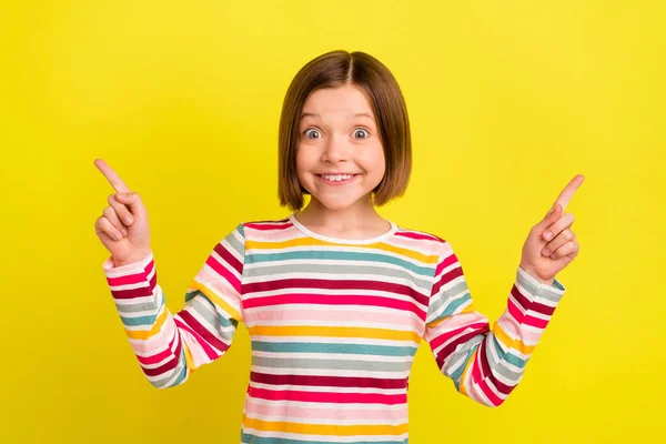 Foto ritratto bambina indossa camicia a righe che punta copyspace sorridente sorpreso isolato vibrante colore giallo sfondo — Foto Stock