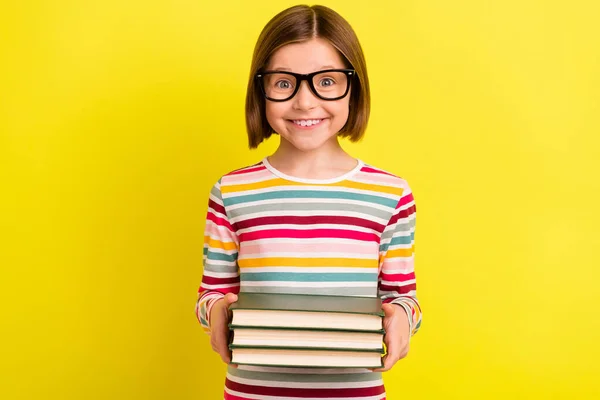 Foto muito positiva jovem menina segurar as mãos livros estudo bom humor isolado no brilho cor amarela fundo — Fotografia de Stock