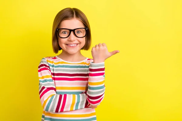 Foto ritratto bambina con pettinatura bob mostrando copyspace con pollice isolato vibrante colore giallo sfondo — Foto Stock