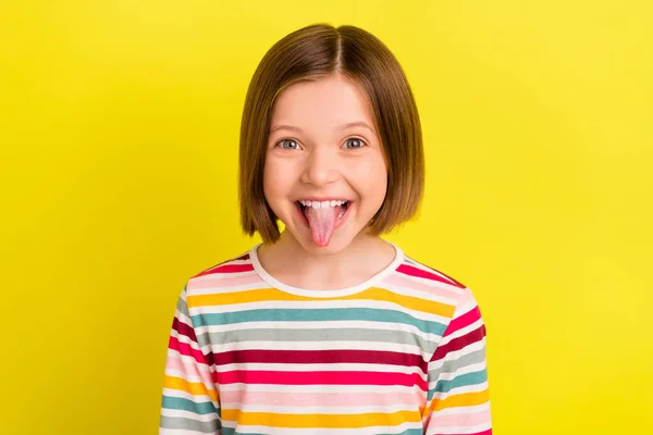 Foto portret klein meisje gek tonen tong grimmig geïsoleerde levendige gele kleur achtergrond — Stockfoto