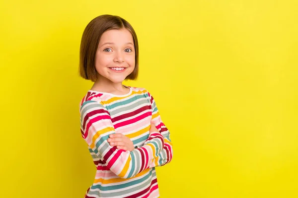 Фото привабливої молодої позитивної маленької дівчинки тримає руки схрещеними впевнено ізольованими на жовтому кольоровому фоні — стокове фото