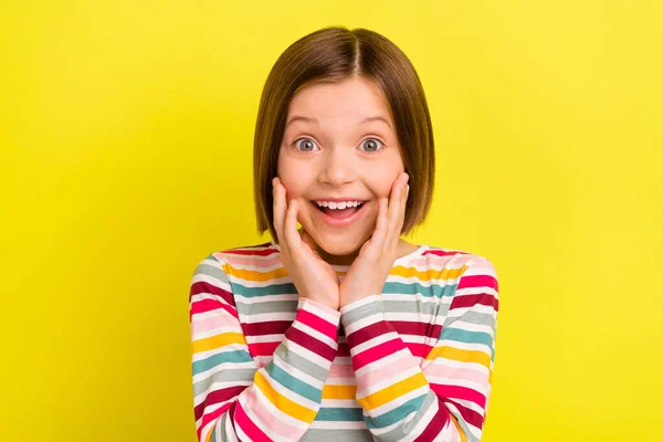 Foto retrato menina em com bob penteado sorrindo espantado tocando bochechas isolado vívido cor amarela fundo — Fotografia de Stock