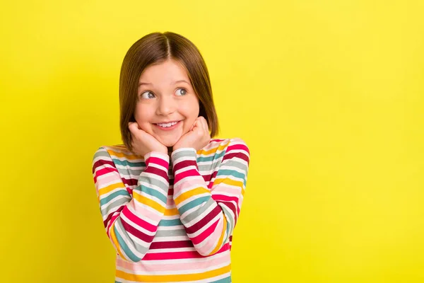 Foto von fröhlich glücklich schönes kleines Mädchen aussehen leeren Raum halten Hände Gesicht isoliert auf leuchtend gelben Hintergrund — Stockfoto