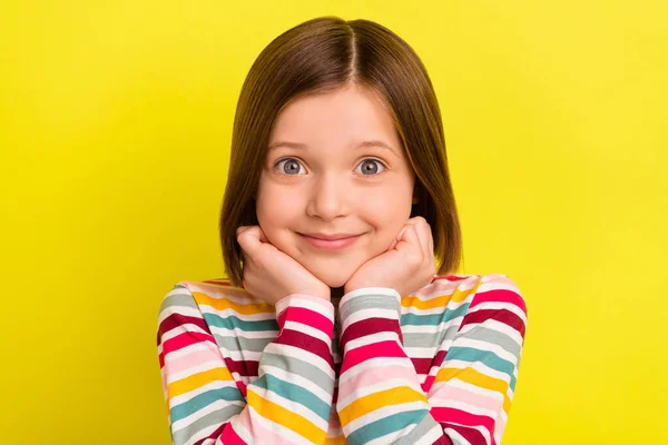 Foto de adorável feliz pequena menina agradável segurar as mãos rosto bom humor sorriso isolado no fundo de cor amarela — Fotografia de Stock