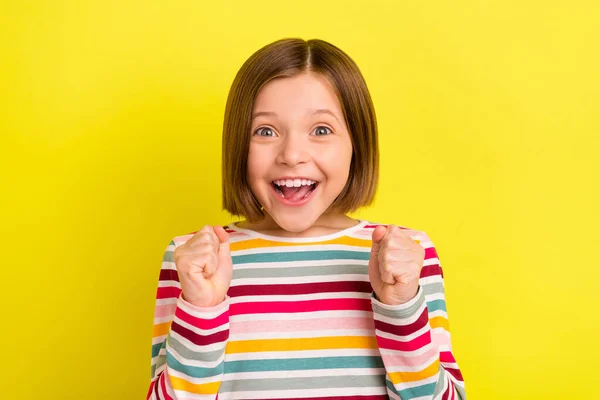 Foto de alegre feliz positiva pequena menina vencedora celebrar sorrisinho isolado no fundo de cor amarela — Fotografia de Stock