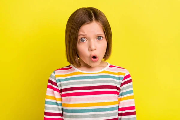 Фотопортрет маленької дівчинки в смугастому одязі виглядає здивованим відкритим ротом ізольований яскраво-жовтий кольоровий фон — стокове фото
