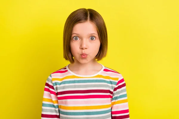 照片上滑稽时髦迷人的小女孩给人送去了一个空吻的好心情，隔离在明亮的黄色背景上 — 图库照片