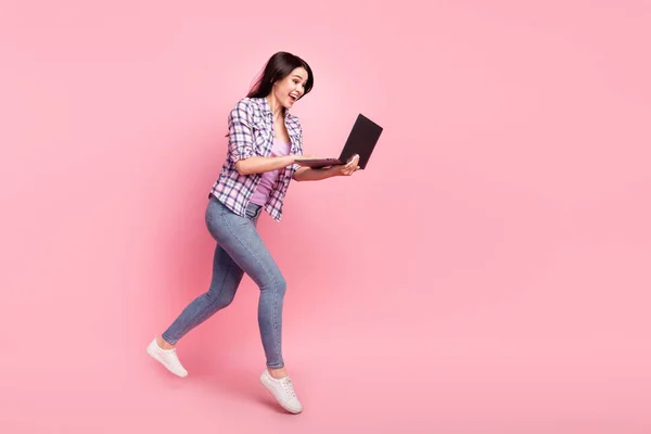 Tamanho total do corpo foto menina em xadrez camisa navegação internet com computador executando isolado pastel cor-de-rosa fundo — Fotografia de Stock