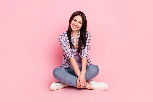 Retrato de menina alegre atraente sentado postura de lótus desfrutando de bom humor isolado sobre fundo de cor pastel rosa — Fotografia de Stock