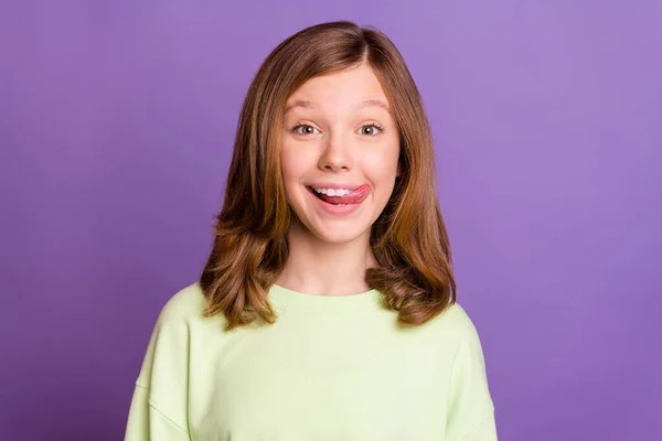 Foto de jovem alegre menina pré-adolescente feliz sorriso positivo lamber lábios língua com fome isolado sobre cor roxa fundo — Fotografia de Stock