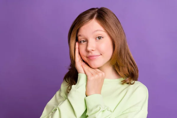 Φωτογραφία του νεαρού ελκυστική preteen κορίτσι ευτυχής θετικό χαμόγελο χέρι αφής μάγουλο απομονωμένο πάνω από μωβ φόντο χρώμα — Φωτογραφία Αρχείου