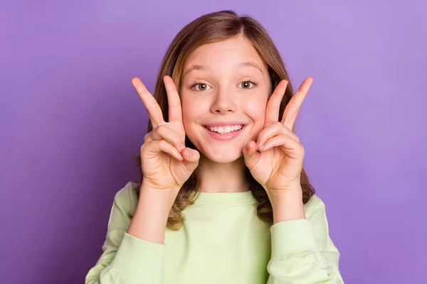 Foto av ung attraktiv skola flicka glad positiv leende visa fred v-tecken rolig isolerad över violett färg bakgrund — Stockfoto