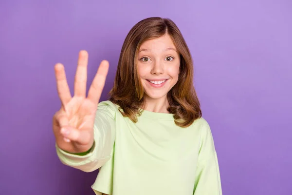 Foto av ung glad flicka glad positiv leende visar tre fingrar mängd matematik isolerad över violett färg bakgrund — Stockfoto