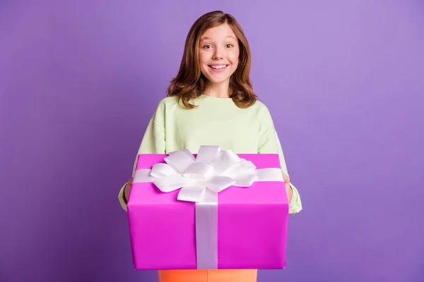 Foto de niña alegre alegre feliz sonrisa positiva dar regalo regalo celebración de cumpleaños aislado sobre fondo de color violeta — Foto de Stock