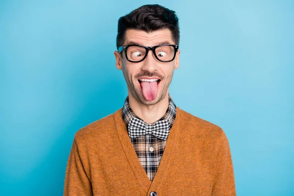 Foto von verrückten lustigen jungen Nerdy Mann stecken Zunge heraus Narren Gesicht Witz isoliert auf blauem Hintergrund — Stockfoto