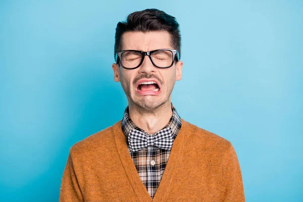 Foto de hombre friki joven molesto llorar mal humor usar gafas corbata de lazo a cuadros aislado en el fondo de color azul — Foto de Stock