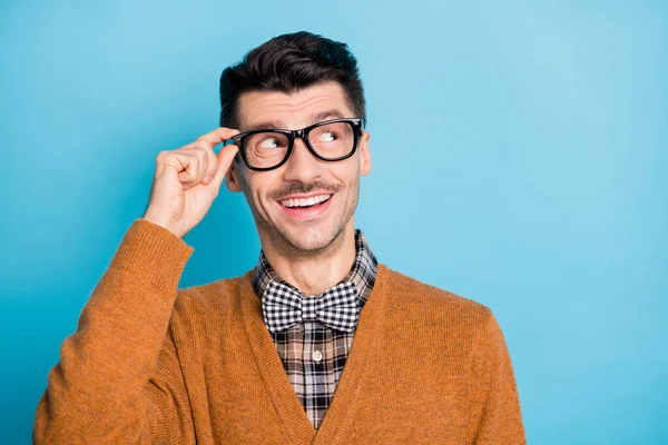 Foto von verträumten glücklichen jungen Mann suchen leeren Raum Touch-Brille Idee isoliert auf blauem Hintergrund — Stockfoto