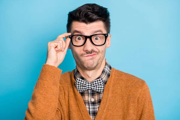 Foto van geschokte onzekere jongeman houden bril denken moeilijke vraag geïsoleerd op blauwe kleur achtergrond — Stockfoto