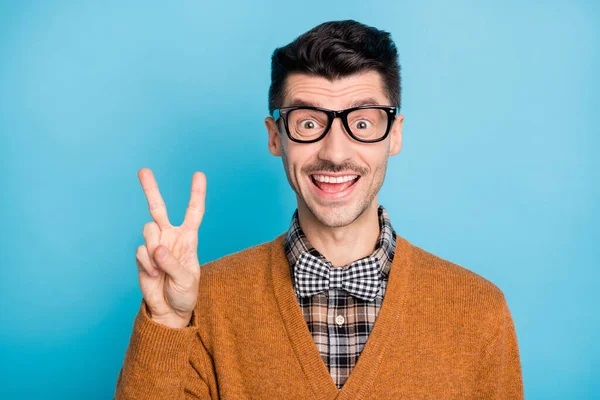 Foto von gut aussehenden jungen Mann halten V-Zeichen gute Laune Nerd Aussenseiter isoliert auf blauem Hintergrund — Stockfoto