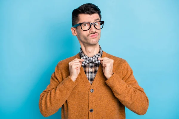 Foto de jovem carismático corrigir laço levantar sobrancelha desconfiança usar óculos isolados no fundo de cor azul — Fotografia de Stock