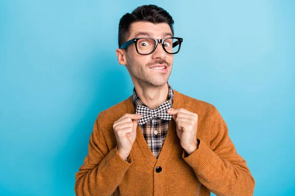 Foto de jovem espantado bonito homem correção xadrez arco gravata desgaste pulôver isolado no fundo de cor azul — Fotografia de Stock