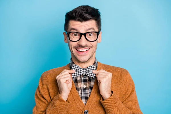 Фото здивованого щасливого чарівного молодого чоловіка, який тримає настроєну краватку весела посмішка ізольована на синьому кольорі — стокове фото