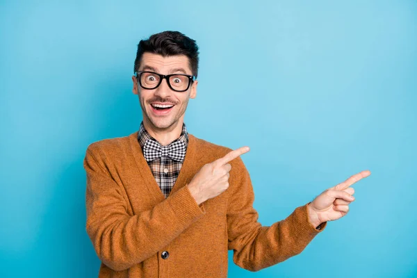 Foto de asombrado joven feliz señalar los dedos vacío espacio shock información aislada sobre fondo de color azul —  Fotos de Stock