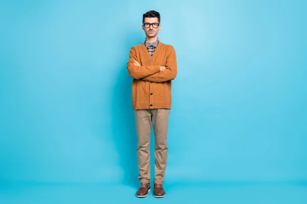 Pełny rozmiar zdjęcie poważnie nakładające młody facet stoją złożone ramiona nosić okulary izolowane na niebieskim tle koloru — Zdjęcie stockowe
