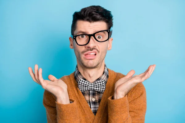 Foto van ongelukkige raadselachtige jongeman verhogen handen dragen bril slecht humeur geïsoleerd op pastel blauwe kleur achtergrond — Stockfoto
