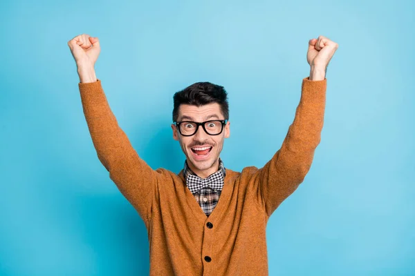 Foto di vittorioso bruna giovane uomo divertente alzare i pugni celebrare vendita shock isolato su sfondo di colore blu — Foto Stock