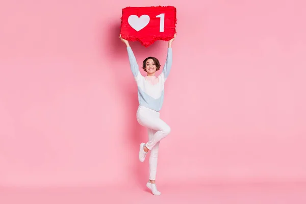 Foto retrato vista de corpo inteiro da menina animado de pé em uma perna segurando grande vermelho como sinal isolado no fundo de cor rosa pastel — Fotografia de Stock