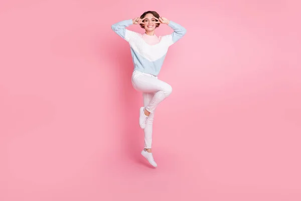 Pełna długość zdjęcie portret dziewczyny pokazuje dwa v-znaków w pobliżu oczu skacząc w górę odizolowany na pastelowym różowym tle — Zdjęcie stockowe