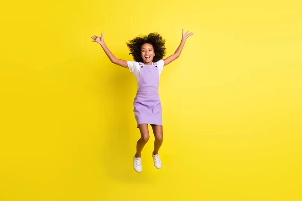 Volledige lengte lichaamsgrootte uitzicht van vrij vrolijke golvende harige meisje springen plezier goed humeur geïsoleerd over levendige gele kleur achtergrond — Stockfoto