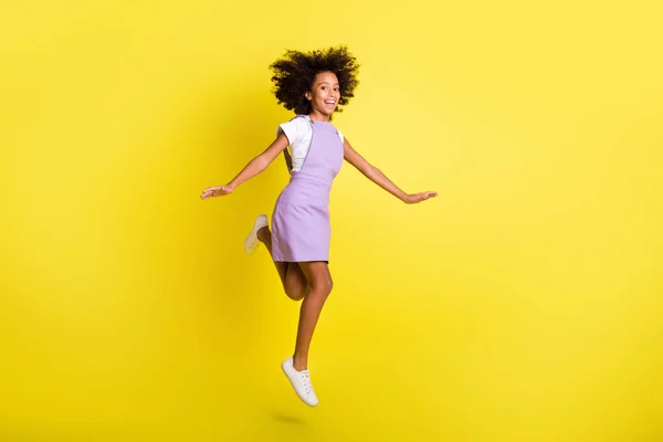 Full length body size view of cheerful carefree wavy-haired girl jumping having fun leisure isolated over bright yellow color background — Stock Photo, Image