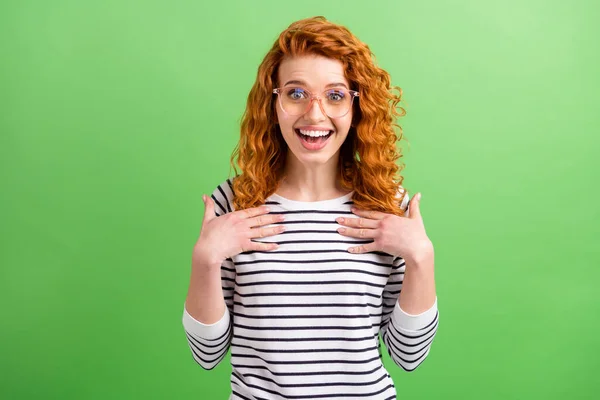 Foto de encantadora mujer joven excitada usar gafas de camisa a rayas apuntando brazos ella misma aislado color verde fondo —  Fotos de Stock